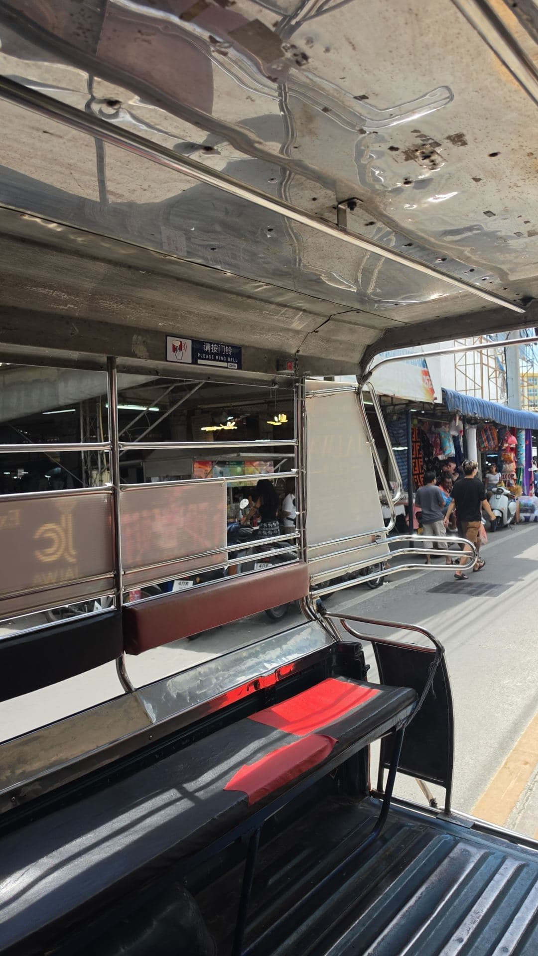 View from the back of a songthaew, a shared pick-up taxi, on a busy street
